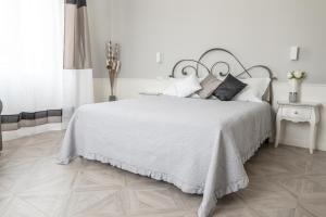 斯培西亚Golfo dei Poeti Retreat的白色卧室配有一张带白色床单和枕头的大床