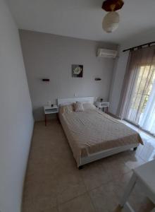 斯卡拉拉乔伊多卡斯旅馆的卧室配有一张床,墙上挂着一个钟