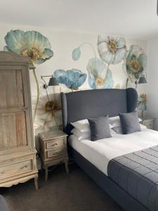 法尔茅斯Falmouth Bay的卧室配有一张挂着蓝色鲜花的床。
