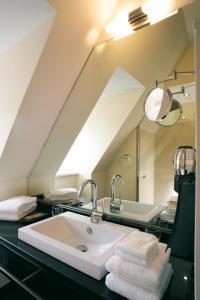 戈斯拉尔Schiefer Suite Hotel & Apartments的一间带水槽和镜子的浴室
