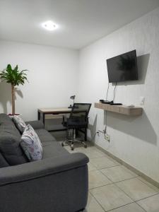 瓜达拉哈拉Luxury Department Tlaquepaque的带沙发、书桌和电视的客厅