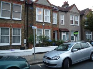 伦敦Boundary Road, 1 Bedroom & 2 Bedroom Flats的停在房子前面的停车场的银色汽车