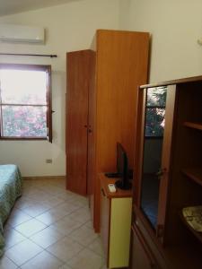 Funtana MeigaMonolocale a 200 metri dal mare的一间卧室配有一张床、一台电视和一个窗口