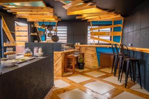 拉巴斯The Grand La Paz Experience Hotel Boutique的厨房铺有木地板,设有带凳子的柜台。