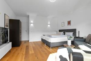 慕尼黑Flatista Homes - Hirschgarten的一间卧室配有一张床和一张沙发