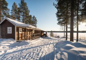 BlattnikseleSandsjögården Holiday Resort的湖边的雪间小屋