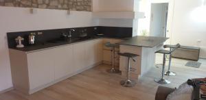 TravedonaCASA DEL LAGO的厨房配有柜台、水槽和凳子