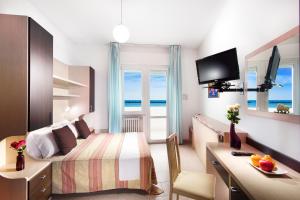 丽都迪萨维奥阿夏戈海滩酒店的酒店客房,设有一张床铺,享有海景