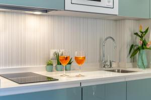 卡拉德米哈斯Divina Home Apartments的厨房柜台上放两杯葡萄酒