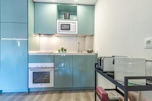 卡拉德米哈斯Divina Home Apartments的厨房配有蓝色橱柜和白色家电