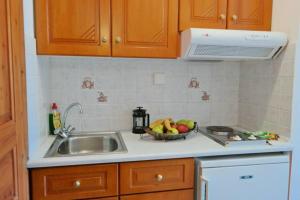AgiassosParadise Studios的厨房配有水槽和一碗水果