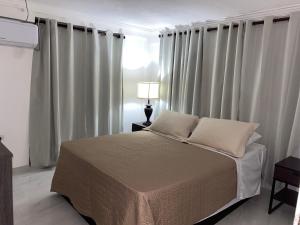 圣安德烈斯Posada Turistica el Swampito的卧室配有一张带白色窗帘的大床