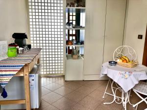 圣马力诺B&B Curva della Palma的厨房配有桌子和椅子及一篮水果