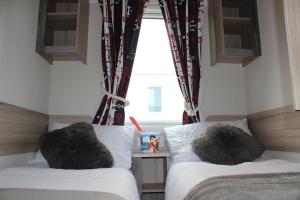 佩伦波斯Perran Sands Perranporth的一间卧室设有两张床和窗户。
