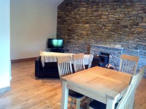 DurrusLittle Glebe Cottage的一间带桌子和砖砌壁炉的用餐室