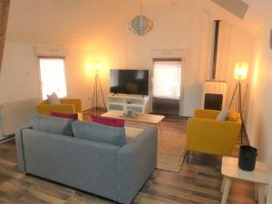 贝尔福Maison de ville, fibre et Netflix的客厅配有沙发、椅子和电视