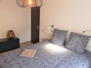 贝尔福Maison de ville, fibre et Netflix的一间卧室配有蓝色的床和两个枕头