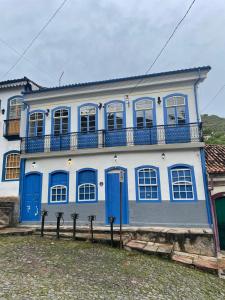 欧鲁普雷图自由之路旅馆的蓝色和白色的房子设有阳台