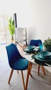 格拉斯哥Beautiful 2bed house with garden, walking distance to town - FREE parking的一间带一张桌子和蓝色椅子的用餐室
