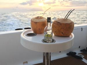 伊甸岛Eden Island Maison 78 (Private Pool)的船上的2个椰子和1瓶桌子