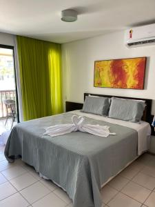 嘎林海斯港Suíte na beira-mar do Resort Marulhos Muro Alto Porto Galinhas的一间卧室,配有一张床,床上有一个弓