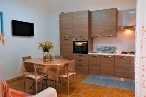 托雷拉皮罗Villa Sette Nani的厨房配有桌椅和电视。