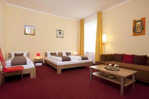 柏林阿本德斯特酒店的一间带两张床和一张沙发的客厅