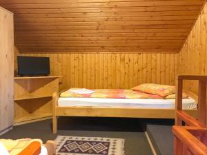 普拉伊德Manó Kulcsosházak的一间小卧室,配有一张位于木制房间内的床