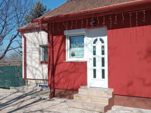 埃尔德Érdi Muskátlis Vendégház的红色和白色的建筑,设有窗户和楼梯