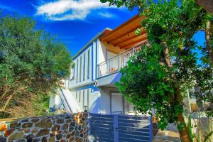 帕琉乔拉Bitsakis Family II - Paleochora Luxury House的白色的房子,有蓝色的栅栏和树木