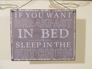 福利尼奥卡希纳安东尼尼酒店的表示如果你想在床上享用早餐,请在厨房睡觉的标志