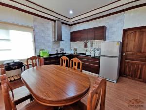 梅尔皮姆Sand-D House Pool Villa A15 at Rock Garden Beach Resort Rayong的厨房配有木桌和冰箱。