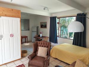 斯泰伦博斯Santika Garden Cottage Stellenbosch的一间卧室配有一张床和一把椅子
