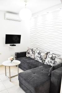 蒂瓦特普诺维科公寓的客厅配有黑色沙发和桌子