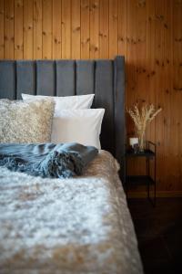 Davos WolfgangChalet Horn的一张带灰色床头板和白色枕头的床
