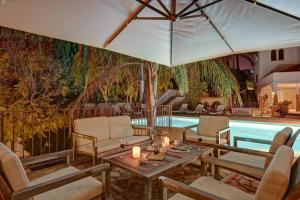 比利亚霍约萨Buccara Villa Mistral的一个带椅子和桌子的游泳池以及一把遮阳伞