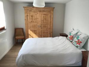 WillgottheimL'atelier du gîte bleu的卧室配有白色的床和木制橱柜。
