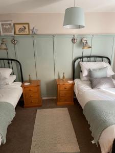 布里奇诺斯Bell Cottage right in the heart of Bridgnorth的一间卧室设有两张床和两个床头柜