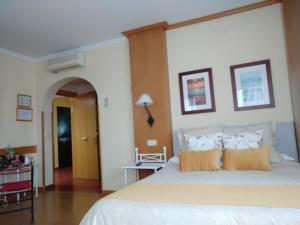 曼萨纳雷斯Área de Servicio El Cruce的卧室配有带橙色枕头的大型白色床