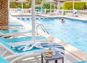 埃斯普霍斯Roquetes Rooms - Formentera Break的游泳池配有椅子和桌子,并提供饮料