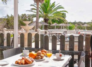 埃斯普霍斯Roquetes Rooms - Formentera Break的餐桌,早餐包括面包和橙汁
