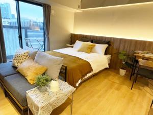 大阪R Hotel Namba的一间卧室配有一张床、一张沙发和一个窗口