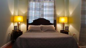 乔治敦Hampton Apartments Guyana的一间卧室配有一张大床和两盏灯