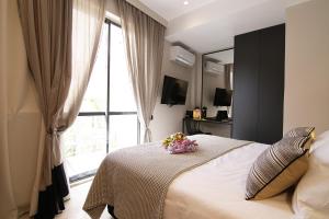 雅典Cityzoe Athens Suites的一间卧室设有一张床,窗户上装有鲜花