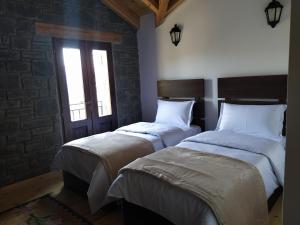 佩尔梅特Chri Chri Guesthouse的带窗户的客房内设有两张单人床。