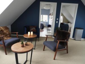锡尔克堡Villa Søholt - Silkeborg Bed and Breakfast的客厅配有桌椅和蓝色的墙壁
