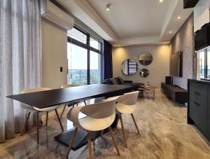 比勒陀利亚Luxurious Menlyn Maine 1 Bedroom on 12th Floor with Stunning Views & No Load Shedding的用餐室以及带桌椅的起居室。
