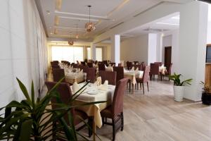 突尼斯Hôtel Lescure Business and SPA的一间在房间内配有桌椅的餐厅