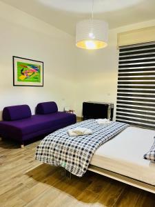 那不勒斯La Vacanzella al Gesu' Nuovo的一间卧室配有一张床和一张紫色沙发