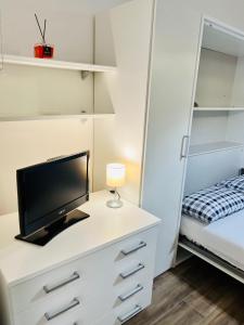 那不勒斯La Vacanzella al Gesu' Nuovo的一间卧室配有一张桌子、一台电视和一张床